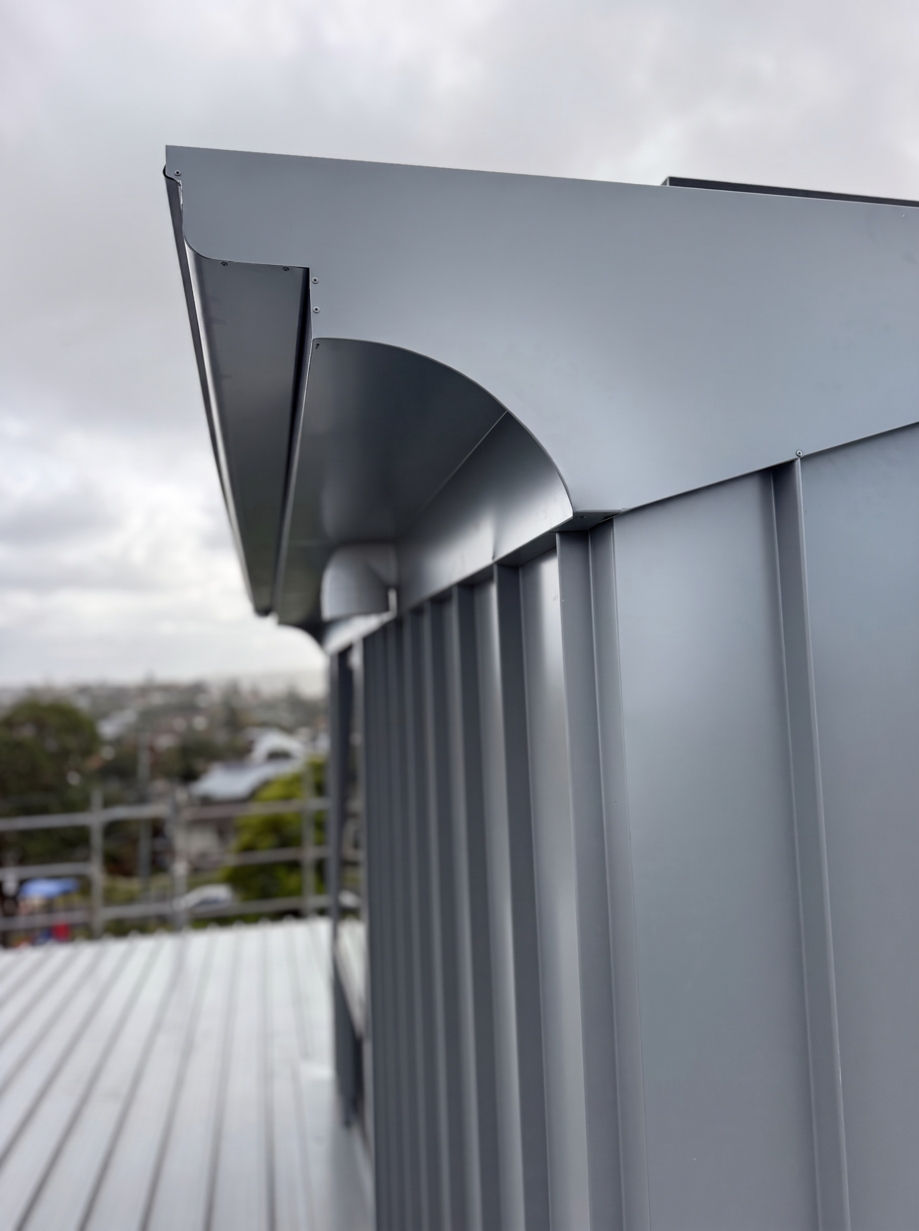 Close-up of custom folded fascia and curved metal soffit